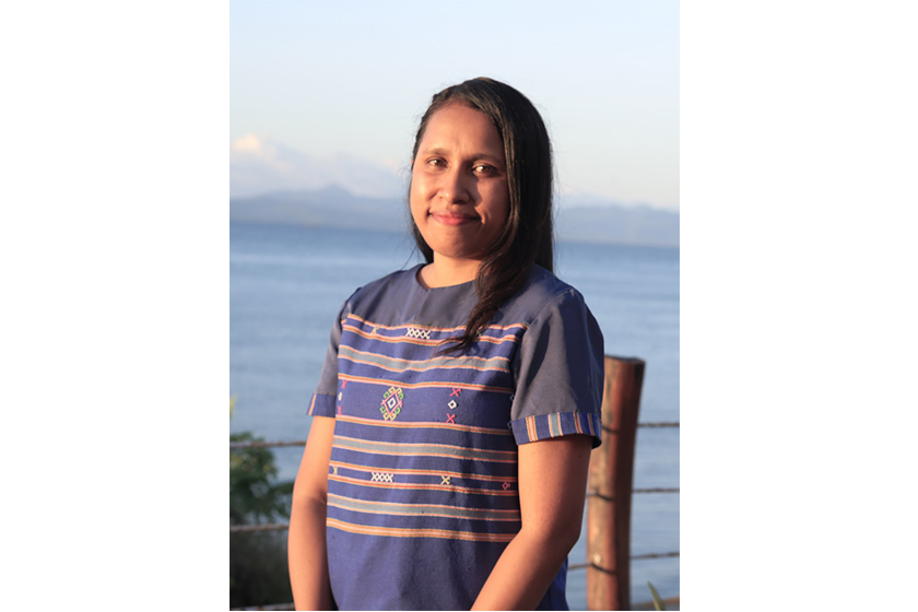 A woman with traditional shirt with beautiful scenery as background